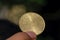 Asian child hand holding a Fifty Halalas Riyal coin, Saudi Arabia money, selected focus and dark background