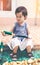 Asian child holding shovel and basket prepared to gardening. Vintage tone.