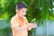 Asian child holding young seedling plant in hands, in garden, on