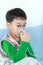 Asian child holds a mask vapor inhaler for treatment of asthma.