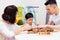 Asian child and parents playing with wooden blocks in the room at home. A kind of educational toys for preschool and kindergarten