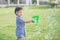 Asian child Shooting Bubbles from Bubble Gun