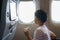 Asian children look at the aerial view of the sky and clouds outside the plane window while sitting on the plane seat