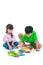 Asian children playing toy wood blocks, on white