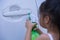 Asian children spry soap to clean car door handle