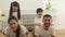 Asian Children tease their parents while exercise training in white living room.