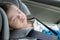 Asian Chinese baby boy asleep while in child safety car seat