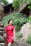 Asian Chinese chi-pao cheongsam woman with classical embroidered fan enjoy relaxed free time ancient town eastern characteristic