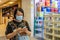 Asian Chinese Lady with medical facemask to Prevention of bacterial infection Corona virus or Covid-19 during walk at shopping