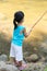 Asian Chinese little girl angling with fishing rod