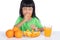 Asian Chinese little girl eating sour orange and making grimace