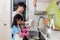 Asian Chinese little girl helping mother washing dishes