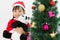 Asian Chinese little girl holding panda doll posing with Christmas Tree