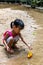 Asian Chinese little girl playing toy boat at creek