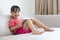 Asian Chinese little girl sitting on the sofa playing digital ta