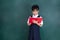 Asian Chinese little Girl in uniform reading book against green