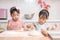 Asian Chinese little sisters making dumpling in the kitchen