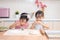 Asian Chinese little sisters making dumpling in the kitchen