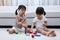 Asian Chinese little sisters playing blocks on the floor