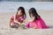 Asian Chinese little sisters playing sand