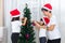 Asian Chinese mother and daughters decorating Christmas tree at