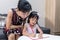 Asian Chinese mother teaching daughter doing homework