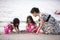 Asian Chinese mum and daughters playing sand together