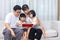 Asian Chinese parents and daughters reading book on the sofa