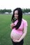 Asian Chinese pregnant woman in yoga dress in nature outdoor smell the flower on hand restful relax life