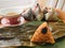 Asian Chinese rice dumplings. Zongzi is placed on the green plate on the leaf, on the wooden tray, there is a cup of chi