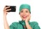 Asian Chinese woman as successful taking selfie on hand phone - young beautiful and happy medicine doctor or hospital nurse taking