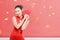 Asian Chinese woman in a cheongsam dress holding red envelopes