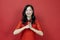 Asian chinese woman in red cheongsam or qipao doing polite respectful gesture for wishing the good luck and prosperity in Chinese