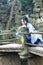 Asian Chinese woman in traditional Blue and white Hanfu dress, play in a famous garden Climb on the bent bridge