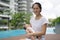 Asian chinese young mother carrying newborn child at her home swimming pool