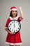 Asian Christmas girl in Santa Claus clothes and clock at midnight
