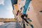 Asian climber woman climbing up outdoor bouldering wall at fitness gym. Fun active sport activity exercise outside