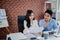 Asian colleagues exchanging ideas on their desks. They work hard every day