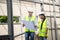 Asian Colleagues worker Specialists team wearing protective safety helmet look at blueprint on Construction Site. Civil Engineer M