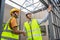 Asian Colleagues worker Specialists team wearing protective safety helmet look at blueprint on Construction Site. Civil Engineer M