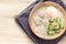 Asian congee with minced pork and egg in white bowl.