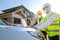 Asian construction engineer Talk to an architect at a construction site using a laptop to explain home design work