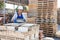 Asian construction shop worker stacks bricks on an open-air site