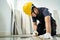 Asian Construction worker installs laminate board on floor in house. Craftsman builder or Carpenter male wear work safety helmet,
