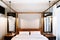 Asian contemporary vintage hotel bedroom with four poster bed, white sheet, pillows