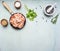 Asian cooking ingredients with fresh small shrimp in a small frying pan, herbs and pepper , wood blue background top view border,