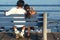 Asian couple on bench at ocean