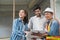 Asian couple checks the work of a contractor building a house for them.