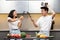 Asian Couple Fencing Holding Cooking Tools Having Fun In Kiitchen