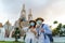 Asian couple happy tourists to travel wearing mask to protect from Covid-19 on they holidays and selfie by camera in Wat arun in